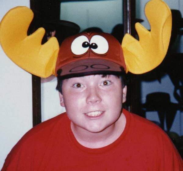 Scott wearing a pair of novelty moose antlers, grinning.